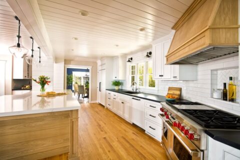 A remodeled kitchen with white cabinets and wood floors