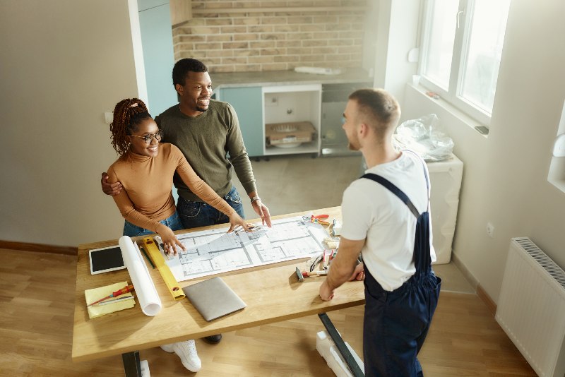 Couple discussing home renovation with man by Bryan Exteriors