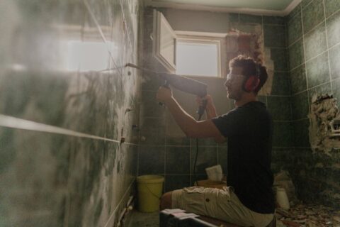 Man renovating bathroom tile by Bryan Exteriors